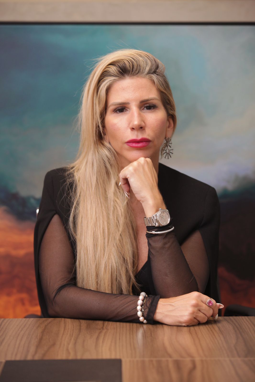 Retrato da autora com traje preto, em postura firme e reflexiva